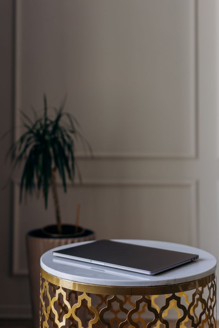 A sleek laptop sits on a stylish table indoors, perfect for modern home office decor.